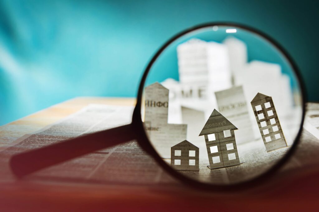 Magnifying glass and paper houses over a map