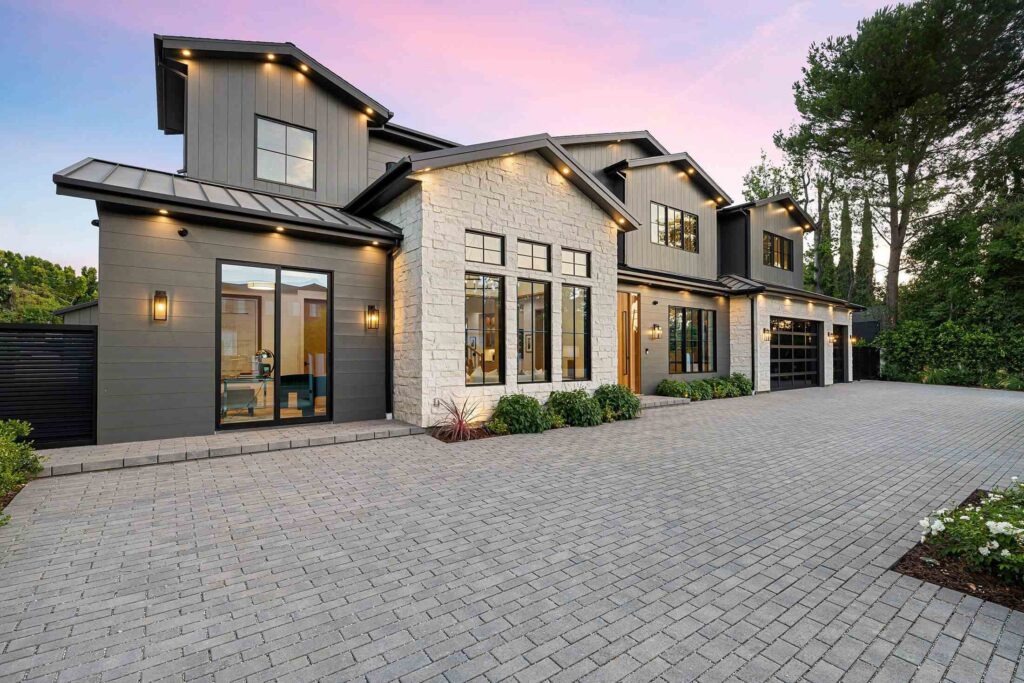 Home with a stone facade and warm exterior lighting